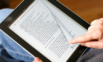 Vista de un lector de libros electrónicos en las manos de un lector que pasa las páginas de un libro digitalizado