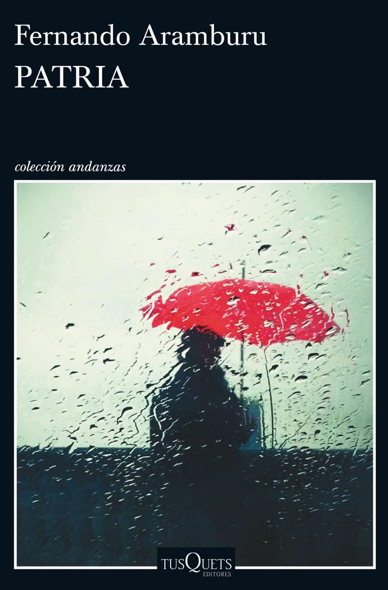 Cubierta del libro Patria, ilustrado con una fotografía de una persona con abrigo y boina, de espaldas, con paraguas rojo, desdibujada a través de un cristal con gotas de lluvia.