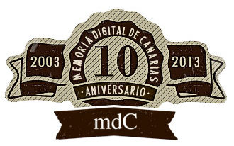 Dibujo gráfico de cinta conmemorativa en tonos grises: a la izquierda de la cinta: 2003, a la derecha, 2013, debajo: mdC. En un medallón central, rodeado por el texto Memoria Digital de Canarias, un diez y, al pie, aniversario.