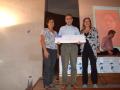 Vista de grupo de la Vicerrectora de Cultura y Deporte, la Directora de la Biblioteca Universitaria y el ganador del segundo premio, quien sostiene un cartel-cheque