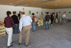 Personas en una sala entre mesas con productos de comercio justo