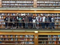 Vista de un lateral de la Sala General de Lectura, con el grupo de alumnas y alumnos en el nivel central