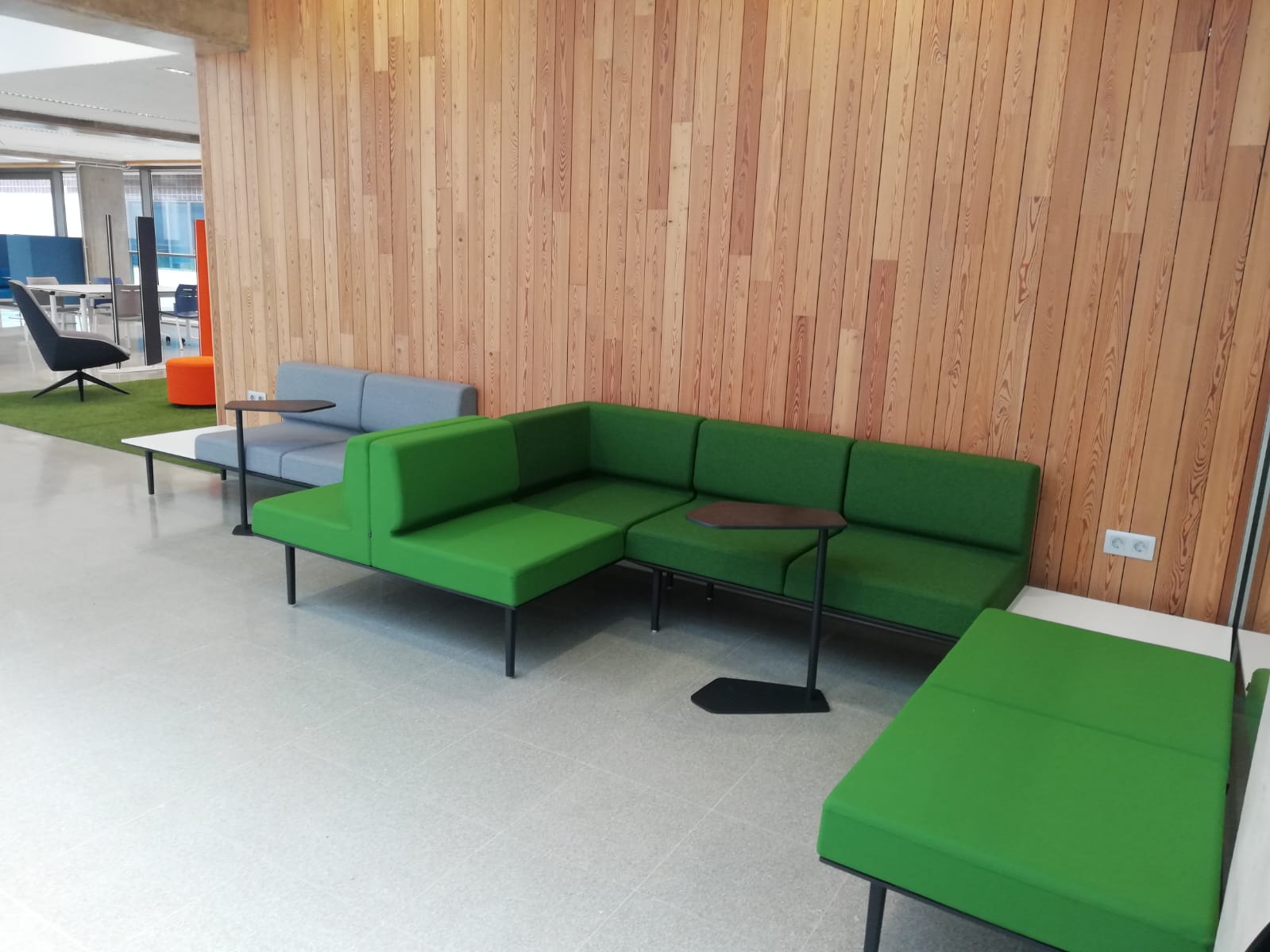 Vista de área de la biblioteca con sofás con 9 plazas y mesillas móviles