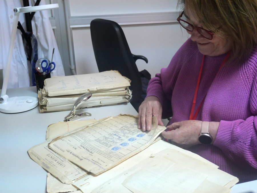 Una mujer hojea un documento antiguo.