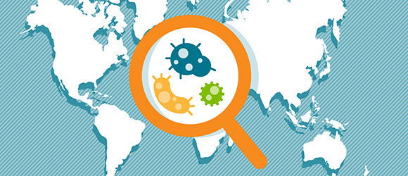 Vista de una lupa aumentando la imagen de microorganismos sobre un mapamundi
