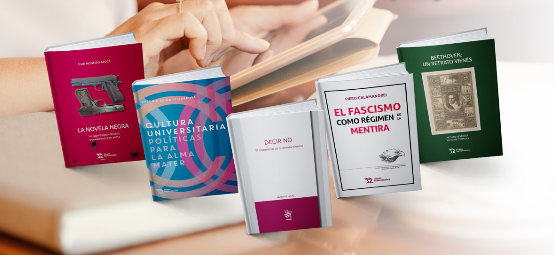Vista de varios libros impresos frente a una persona trabajando en un ordenador portátil