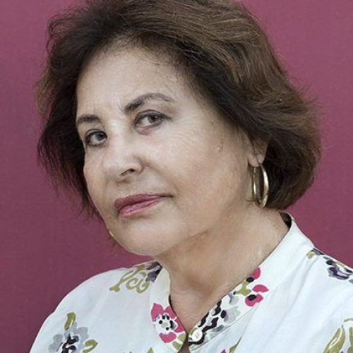 Mujer mira a cámara con la cabeza ladeada