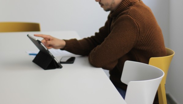 Estudiante sentado con tablet y móvil